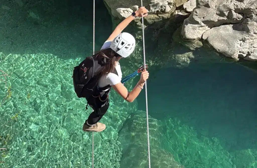 Participant descending on a rope above Brina Canyon