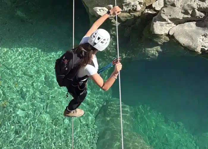 Participant descending on a rope above Brina Canyon