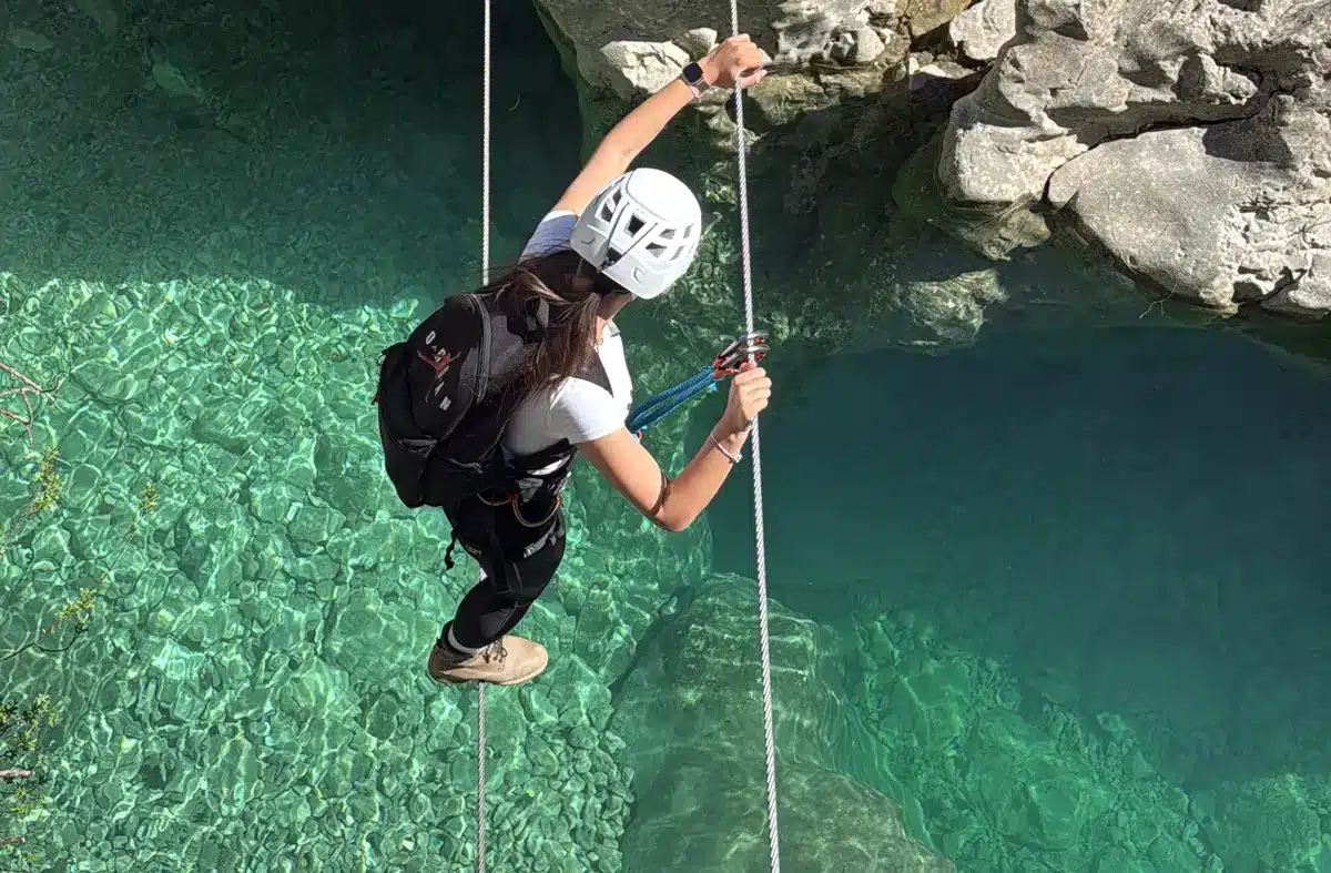 Participant descending on a rope above Brina Canyon
